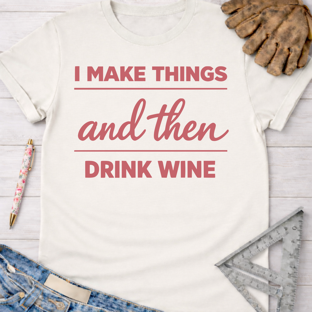 Women's funny woodworking graphic tee shirt for female woodworkers, makers, and DIY builders — Sawdust & Ponytails. Cream cotton tee with "I Make Things and Then Drink Wine" in pink text, styled with jeans, work gloves, and tools.