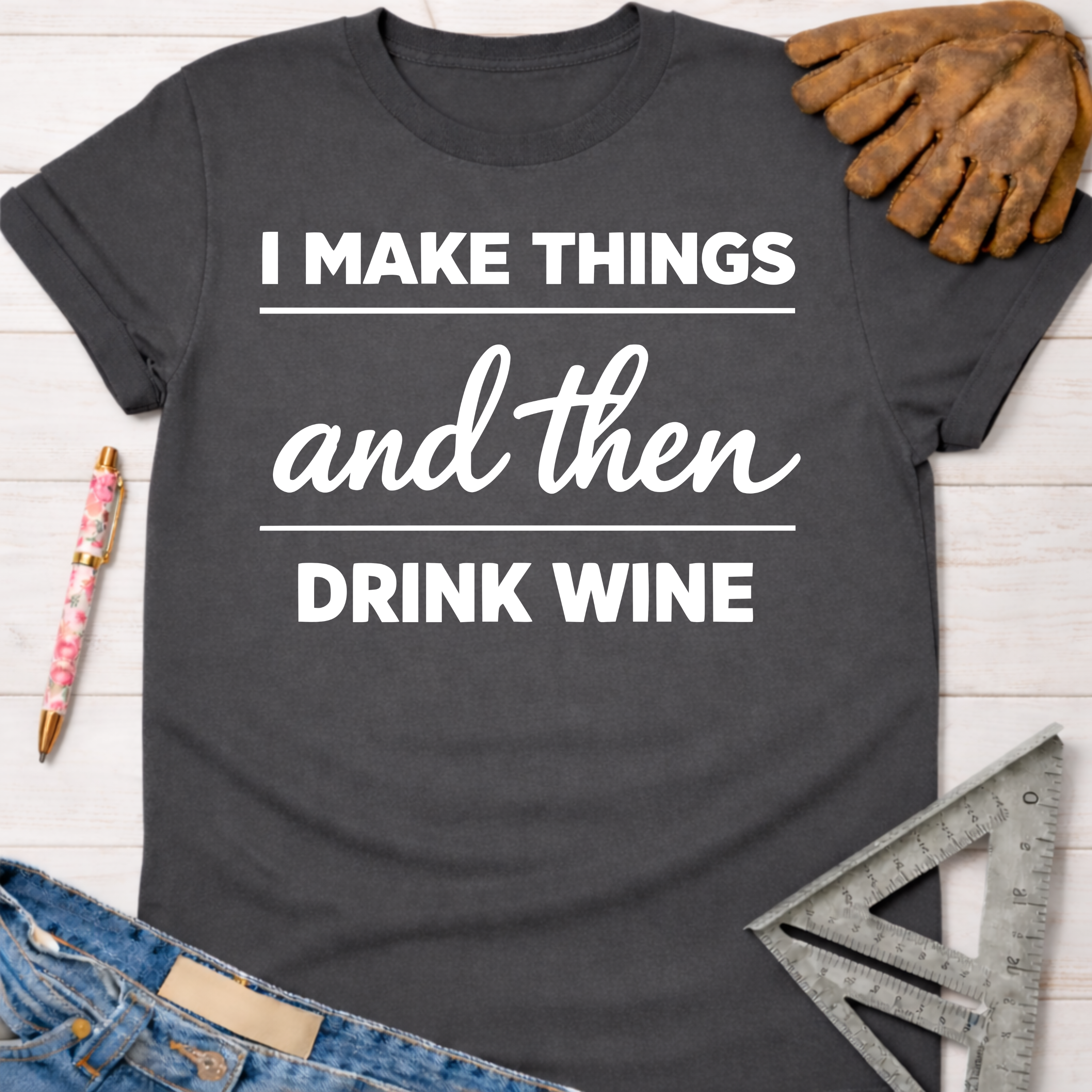 Women's funny woodworking graphic tee shirt for female woodworkers, makers, and DIY builders — Sawdust & Ponytails. Dark gray cotton tee with "I MAKE THINGS and then DRINK WINE" in white text.