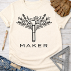 Women's funny woodworking graphic tee shirt for female woodworkers, makers, and DIY builders — Sawdust & Ponytails. Cream t-shirt with a black floral hammer and "MAKER" graphic.