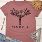 Women's funny woodworking graphic tee shirt for female woodworkers, makers, and DIY builders — Sawdust & Ponytails. Mauve t-shirt with a floral hammer graphic and "MAKER" text.