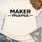 Women's funny woodworking graphic tee shirt for female woodworkers, makers, and DIY builders — Sawdust & Ponytails. Cream t-shirt with "MAKER mama" in black text.
