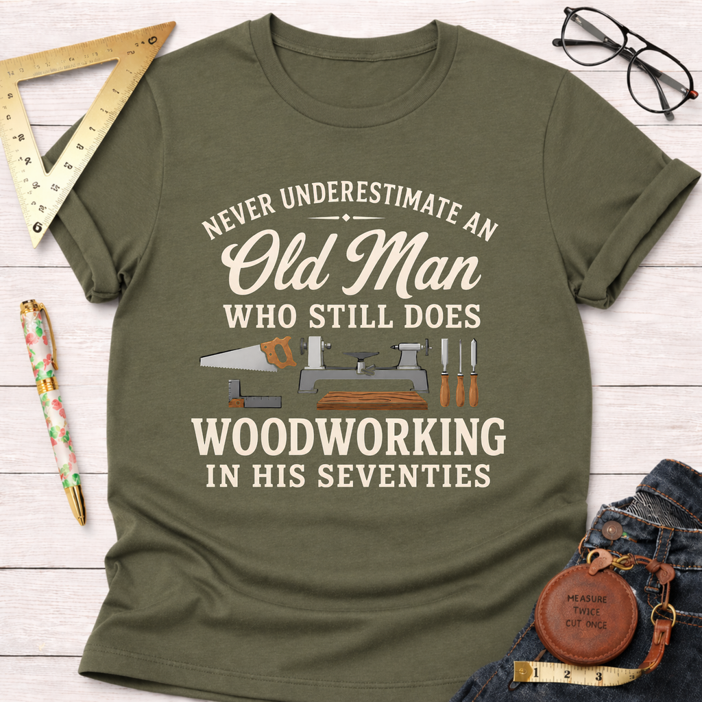 Olive green t-shirt with "Never Underestimate An Old Man Who Still Does Woodworking In His Seventies" text and tools.