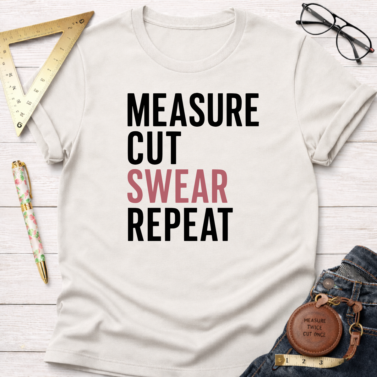 Off-white cotton t-shirt with "MEASURE CUT SWEAR REPEAT" graphic, surrounded by woodworking tools.