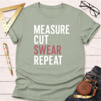 Light green "Measure Cut Swear Repeat" graphic tee for woodworkers, with ruler, pen, and jeans.