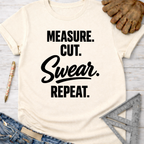 Cream t-shirt with "Measure. Cut. Swear. Repeat." in black text. Women's funny woodworking graphic tee shirt for female woodworkers, makers, and DIY builders — Sawdust & Ponytails.