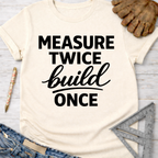 Women's funny woodworking graphic tee shirt for female woodworkers, makers, and DIY builders — Sawdust & Ponytails. Cream t-shirt with "Measure Twice Build Once" in black text.