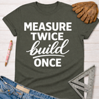 Women's funny woodworking graphic tee shirt for female woodworkers, makers, and DIY builders — Sawdust & Ponytails. Dark gray cotton tee with "Measure Twice Build Once" in white text.
