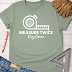 Women's funny woodworking graphic tee shirt for female woodworkers, makers, and DIY builders — Sawdust & Ponytails. Sage green cotton t-shirt with "Measure Twice Cry Once" and tape measure graphic.