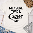 Women's funny woodworking graphic tee shirt for female woodworkers, makers, and DIY builders — Sawdust & Ponytails. White cotton t-shirt with "Measure Twice. Curse Once." in black text.