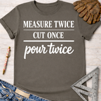 Women's funny woodworking graphic tee shirt for female woodworkers, makers, and DIY builders — Sawdust & Ponytails. Dark gray short-sleeve t-shirt with "MEASURE TWICE CUT ONCE pour twice" in white text.