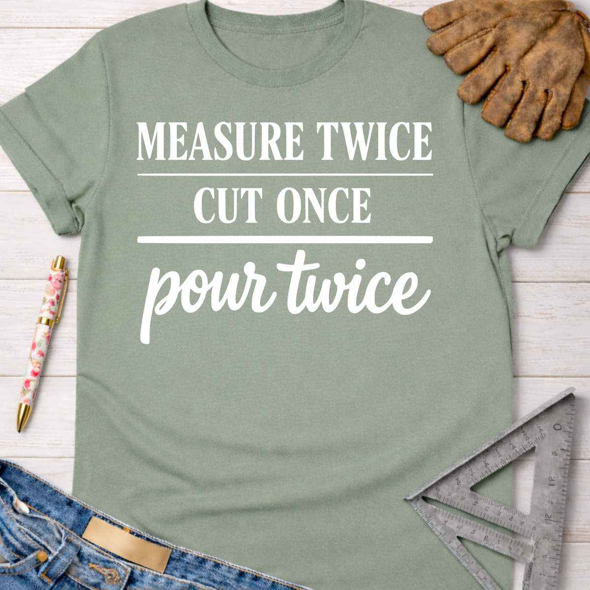 Women's funny woodworking graphic tee shirt for female woodworkers, makers, and DIY builders — Sawdust & Ponytails. Sage green cotton tee with "MEASURE TWICE CUT ONCE pour twice" in white text.