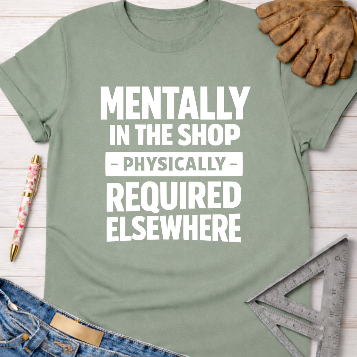 Sage green women's tee with "Mentally In The Shop - Physically - Required Elsewhere" graphic. Women's funny woodworking graphic tee shirt for female woodworkers, makers, and DIY builders — Sawdust & Ponytails