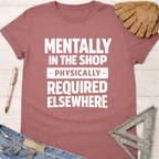 Women's funny woodworking graphic tee shirt for female woodworkers, makers, and DIY builders — Sawdust & Ponytails. Mauve cotton tee with "Mentally In The Shop - Physically - Required Elsewhere" in white text.