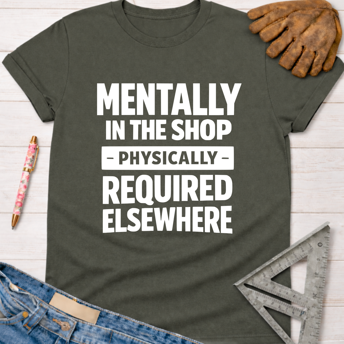 Dark gray "Mentally In The Shop - Physically - Required Elsewhere" tee with jeans, glove, and ruler. Women's funny woodworking graphic tee shirt for female woodworkers, makers, and DIY builders — Sawdust & Ponytails