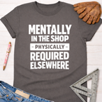 Charcoal gray women's "Mentally In The Shop" tee with white text, jeans, work glove, and ruler. Sawdust & Ponytails.