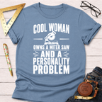 Light blue cotton t-shirt with "Cool Woman Owns A Miter Saw And A Personality Problem" graphic.