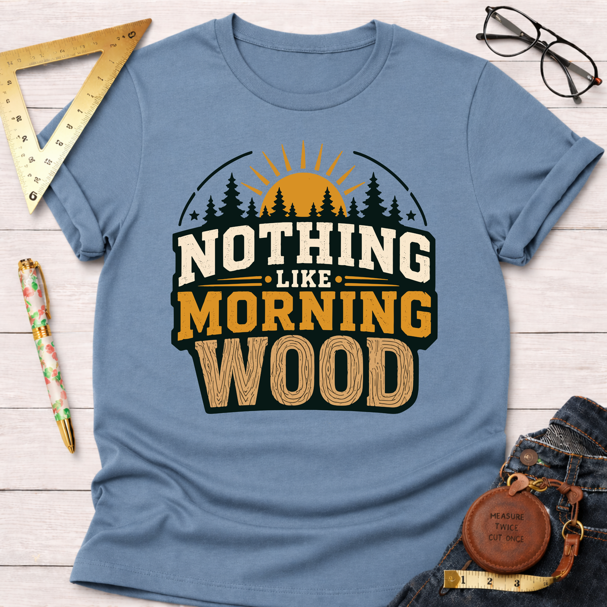 Light blue cotton t-shirt with "NOTHING LIKE MORNING WOOD" text, trees, and sun graphic.