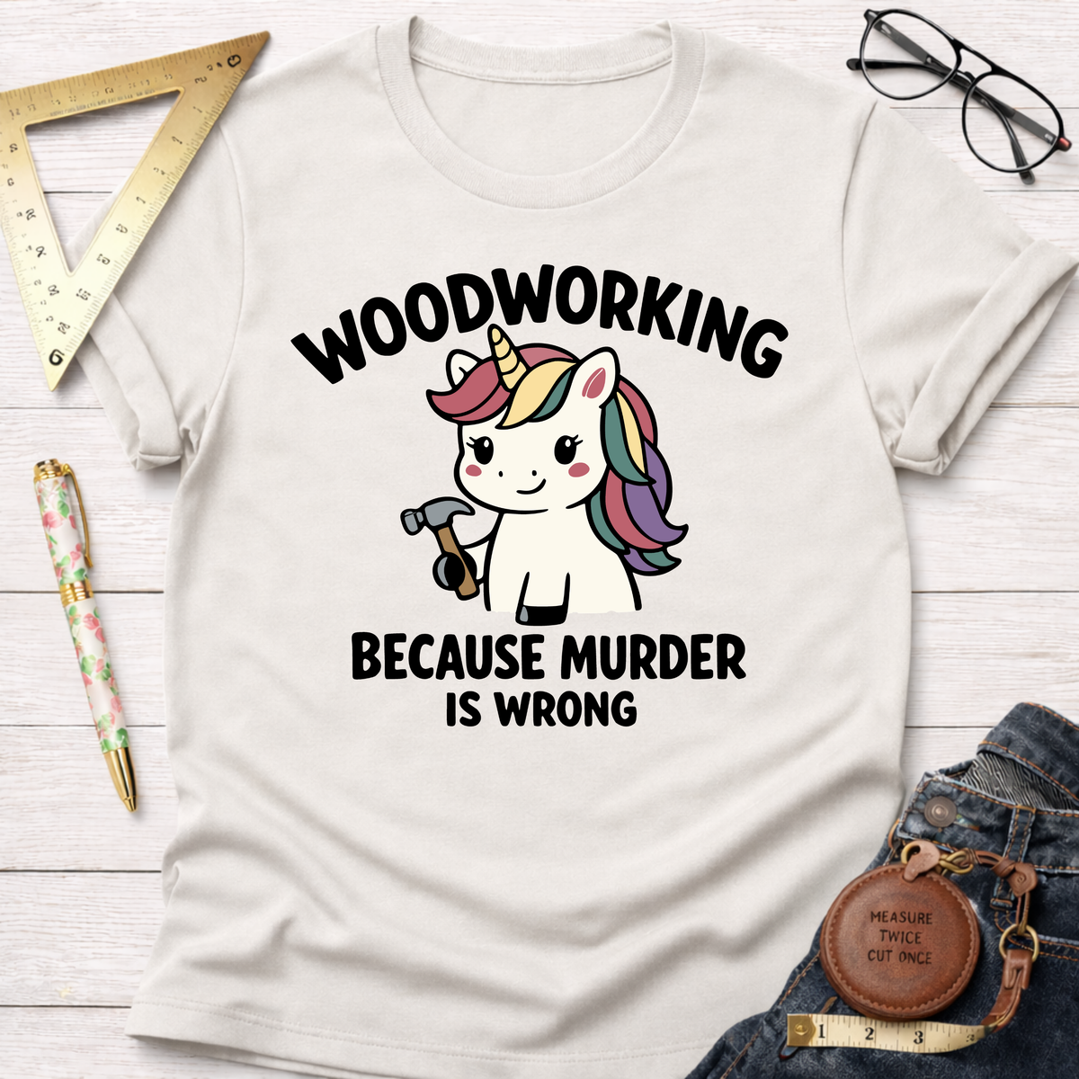 White t-shirt with "Woodworking Because Murder Is Wrong" text and a cute unicorn holding a hammer.