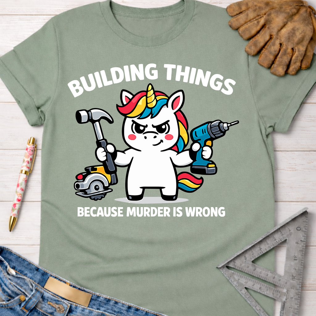 Women's funny woodworking graphic tee shirt for female woodworkers, makers, and DIY builders — Sawdust & Ponytails. Light green cotton t-shirt with a cartoon unicorn holding a hammer and power drill, "BUILDING THINGS BECAUSE MURDER IS WRONG" text.