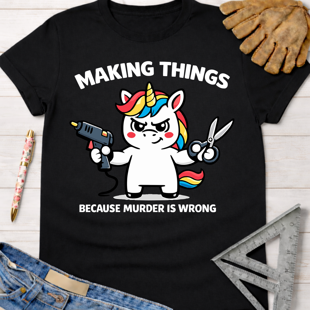 Black cotton tee with a funny unicorn holding a glue gun and scissors, text "Making Things Because Murder Is Wrong." Women's funny woodworking graphic tee shirt for female woodworkers, makers, and DIY builders — Sawdust & Ponytails