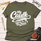 Olive green "My Caulk Game Is On Point" t-shirt with a caulk gun graphic, displayed flat with tools.