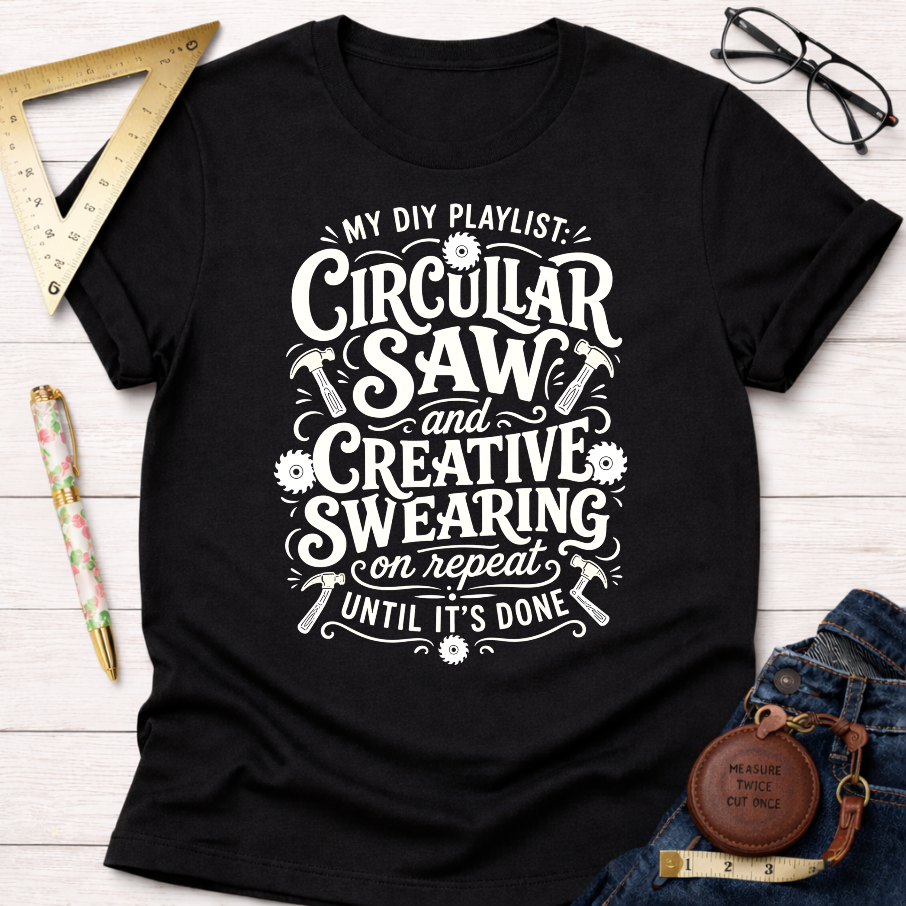 Women's funny woodworking graphic tee shirt for female woodworkers, makers, and DIY builders — Sawdust & Ponytails. Black cotton tee with "My DIY Playlist: Circular Saw and Creative Swearing on Repeat Until It's Done" in white script.