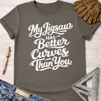 Women's funny woodworking graphic tee shirt for female woodworkers, makers, and DIY builders — Sawdust & Ponytails. Dark gray cotton tee with "My Jigsaw Has Better Curves Than You" in white script.
