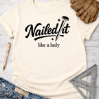 Women's funny woodworking graphic tee shirt for female woodworkers, makers, and DIY builders — Sawdust & Ponytails. Cream t-shirt with "Nailed It like a lady" in black script.