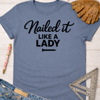Women's funny woodworking graphic tee shirt for female woodworkers, makers, and DIY builders — Sawdust & Ponytails. Blue cotton tee with "Nailed it LIKE A LADY" in black script.