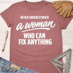 Women's funny woodworking graphic tee shirt for female woodworkers, makers, and DIY builders — Sawdust & Ponytails. Mauve cotton t-shirt with "Never Underestimate a Woman Who Can Fix Anything" in white text.