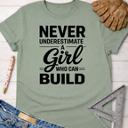 Women's funny woodworking graphic tee shirt for female woodworkers, makers, and DIY builders — Sawdust & Ponytails. Sage green cotton t-shirt with "Never Underestimate A Girl Who Can Build" in black text.