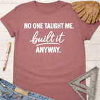 Women's funny woodworking graphic tee shirt for female woodworkers, makers, and DIY builders — Sawdust & Ponytails. Mauve cotton t-shirt with "NO ONE TAUGHT ME. built it ANYWAY." in white text.