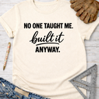 Women's funny woodworking graphic tee shirt for female woodworkers, makers, and DIY builders — Sawdust & Ponytails. Cream t-shirt with "NO ONE TAUGHT ME. built it ANYWAY." text.