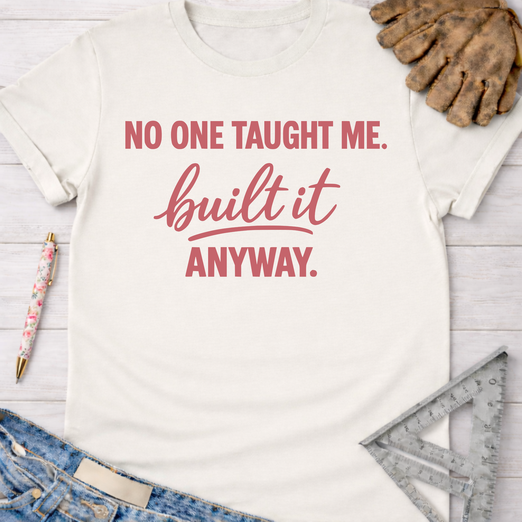 Women's funny woodworking graphic tee shirt for female woodworkers, makers, and DIY builders — Sawdust & Ponytails. Cream t-shirt with "NO ONE TAUGHT ME. built it ANYWAY." in pink text, styled with jeans, work gloves, and a ruler.