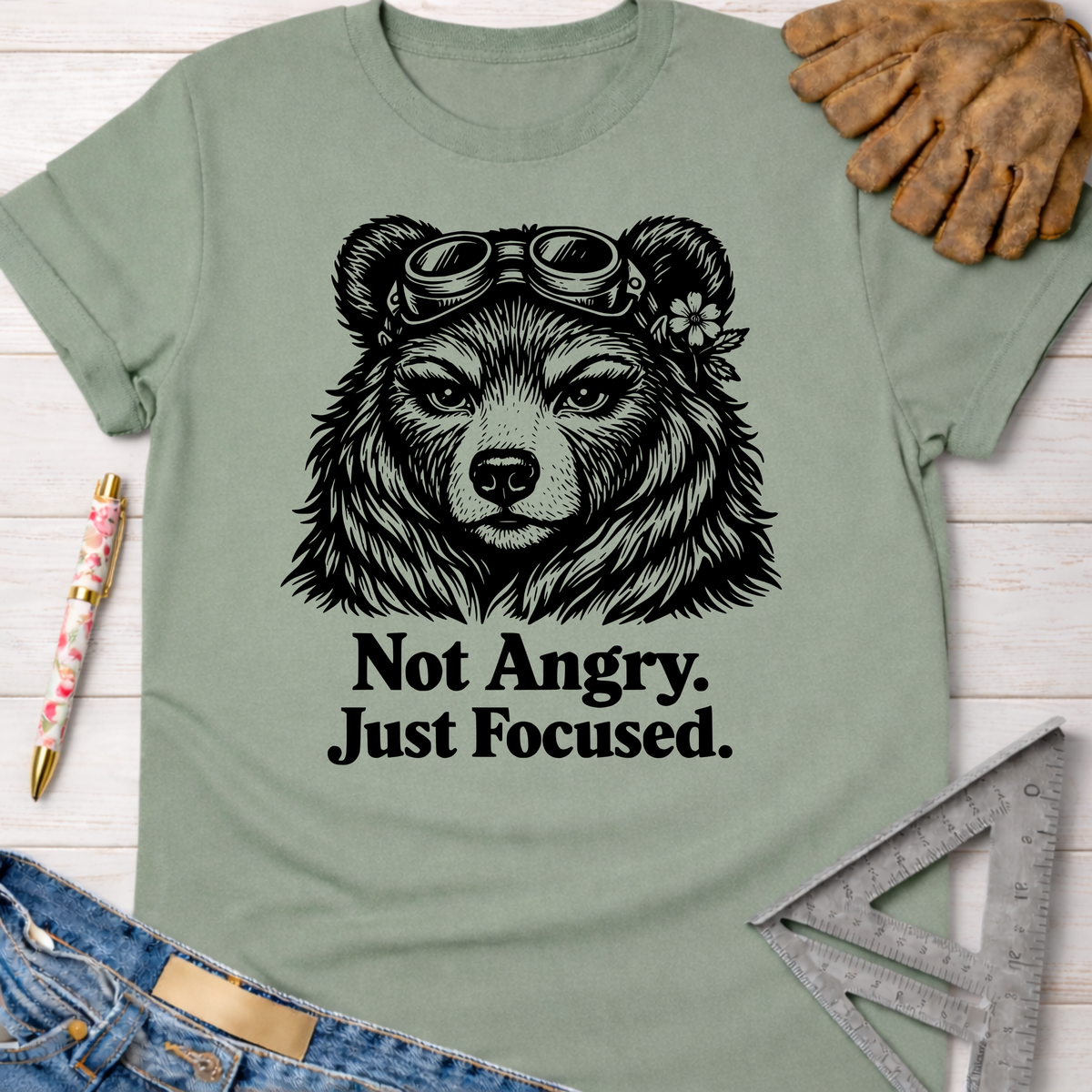 Sage green women's funny woodworking graphic tee with a focused bear in goggles, "Not Angry. Just Focused." text.