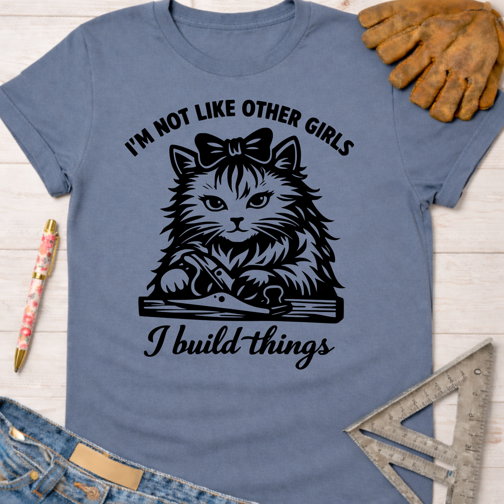 Women's funny woodworking graphic tee shirt for female woodworkers, makers, and DIY builders — Sawdust & Ponytails. Blue cotton tee with black graphic of a cat using a hand plane, text "I'm not like other girls I build things".