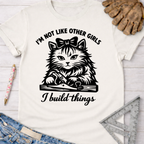 Women's funny woodworking graphic tee shirt for female woodworkers, makers, and DIY builders — Sawdust & Ponytails. White cotton tee with a black graphic of a cat using a hand plane, text "I'm not like other girls, I build things.