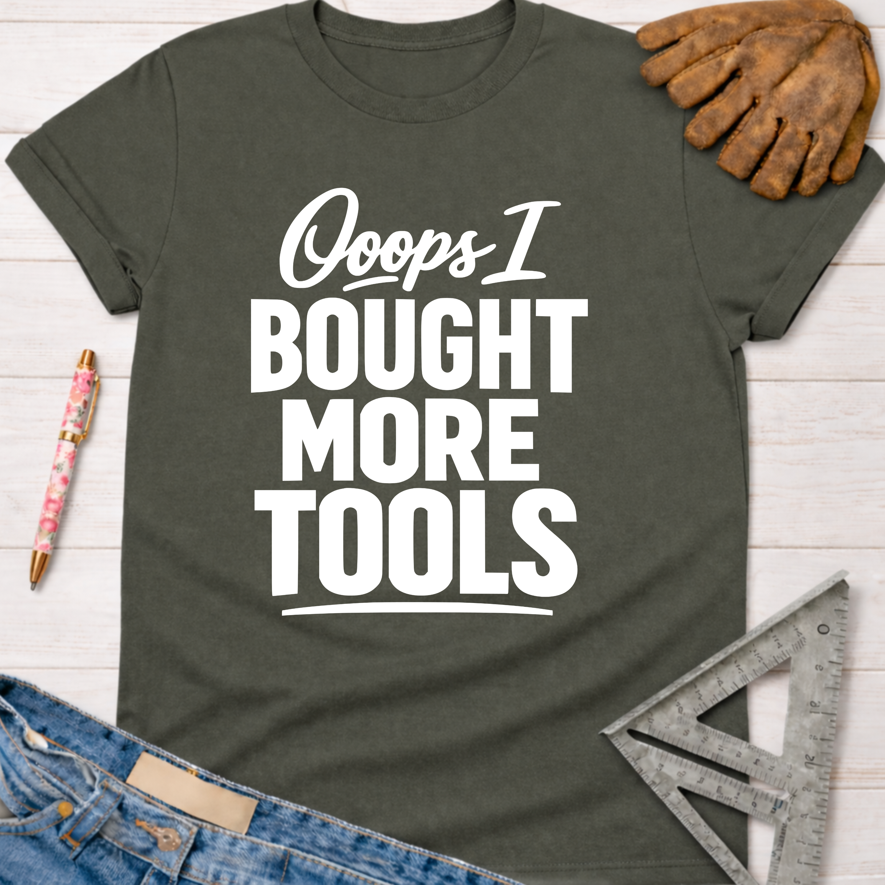 Women's funny woodworking graphic tee shirt for female woodworkers, makers, and DIY builders — Sawdust & Ponytails. Dark gray cotton tee with "Ooops I Bought More Tools" in white text.