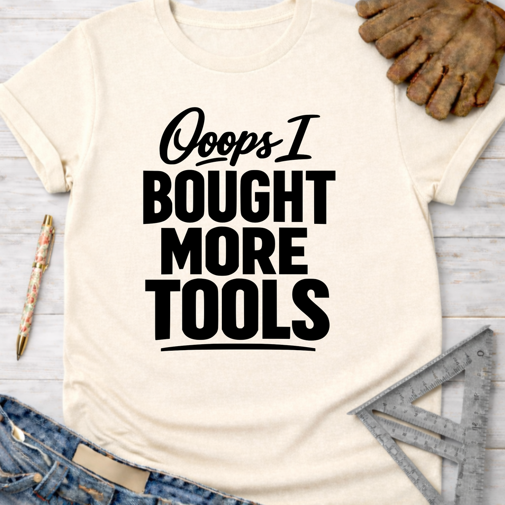 Women's funny woodworking graphic tee shirt for female woodworkers, makers, and DIY builders — Sawdust & Ponytails. Cream short-sleeve t-shirt with "Ooops I BOUGHT MORE TOOLS" in black text.