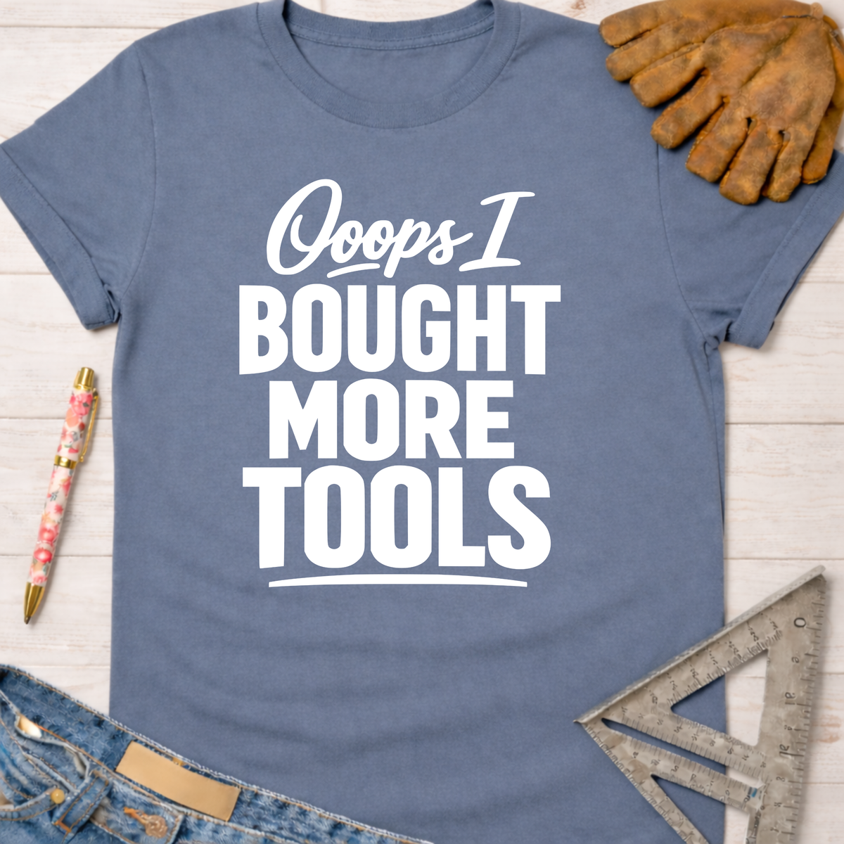 Women's funny woodworking graphic tee shirt for female woodworkers, makers, and DIY builders — Sawdust & Ponytails. Blue cotton tee with "Ooops I Bought More Tools" in white text.