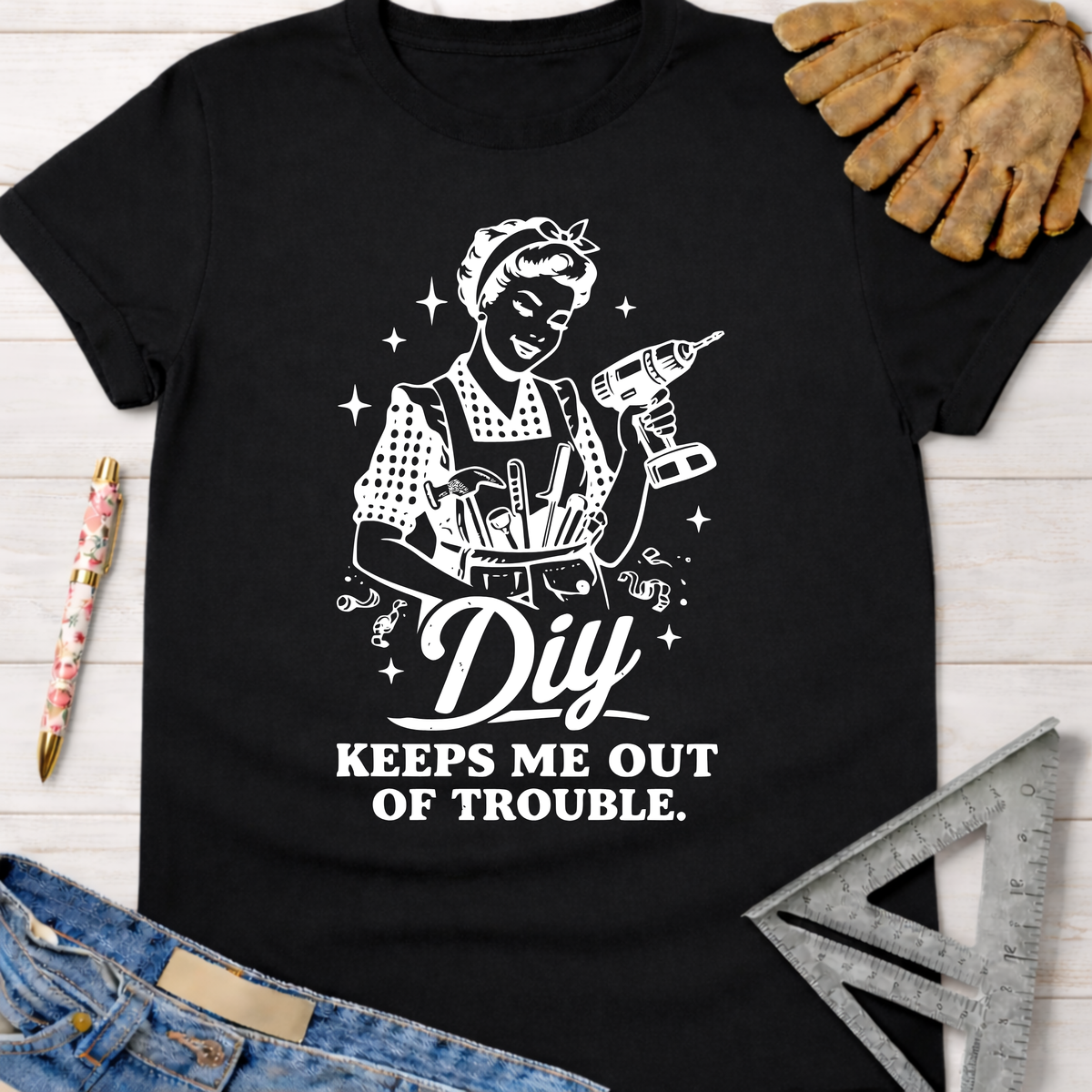 Black cotton women's "DIY Keeps Me Out Of Trouble" graphic tee with Rosie the Riveter-style builder.