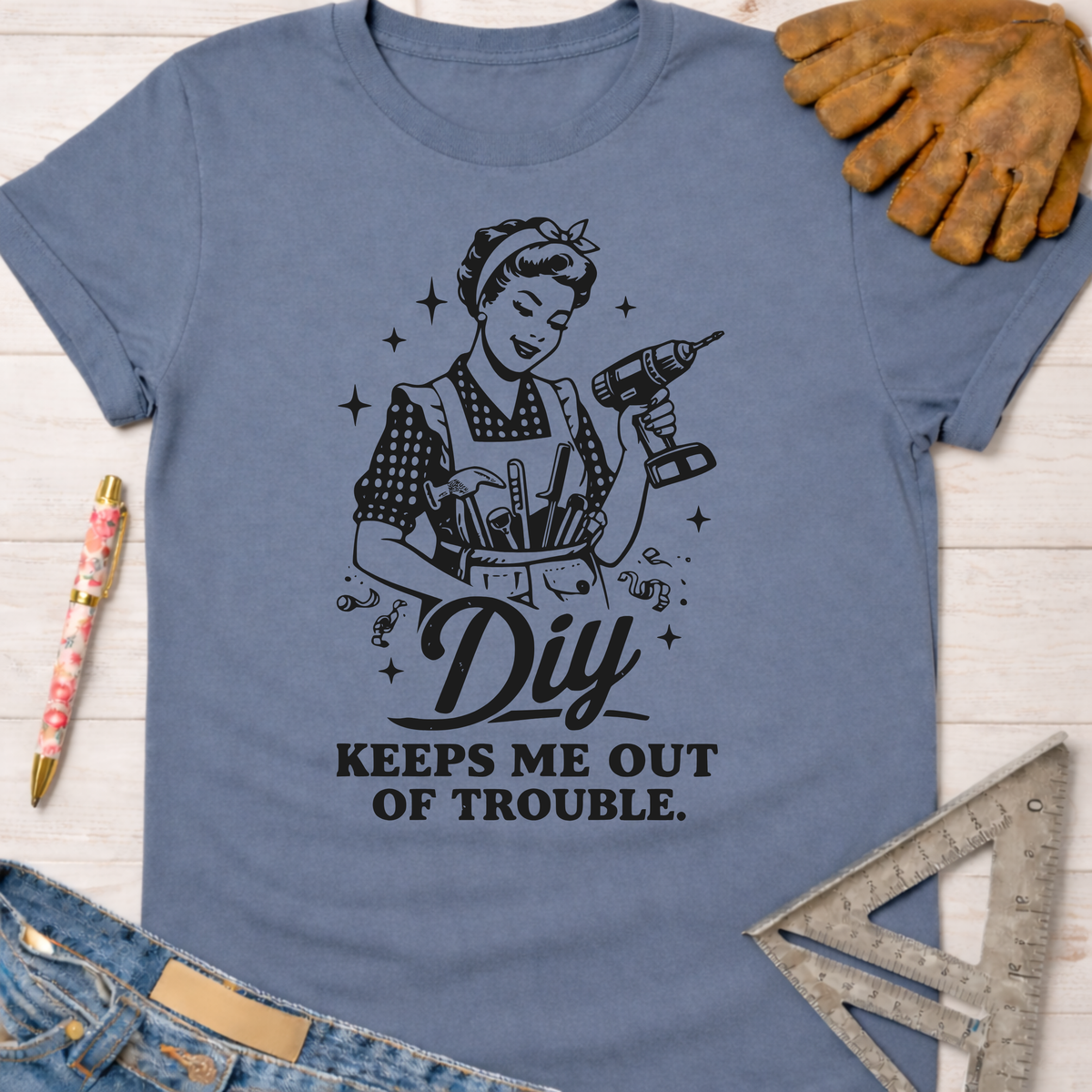 Women's funny woodworking graphic tee shirt for female woodworkers, makers, and DIY builders — Sawdust & Ponytails. Blue cotton tee with "DIY Keeps Me Out Of Trouble" graphic.
