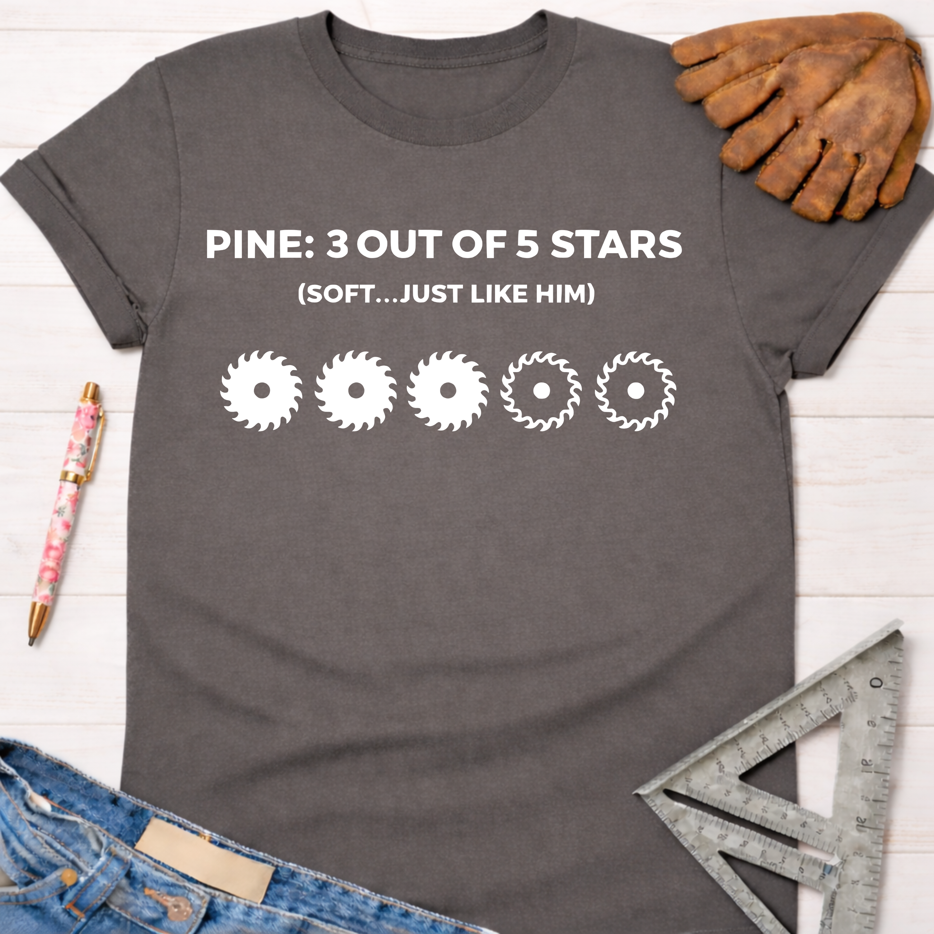 Women's funny woodworking graphic tee shirt for female woodworkers, makers, and DIY builders — Sawdust & Ponytails. Dark gray cotton tee with "PINE: 3 OUT OF 5 STARS (SOFT...JUST LIKE HIM)" and three full saw blade icons.