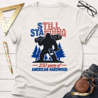 Patriotic Sasquatch t-shirt with "Still Standing" text, Bigfoot holding a log and axe, and "250 years of American Hardwood" text.