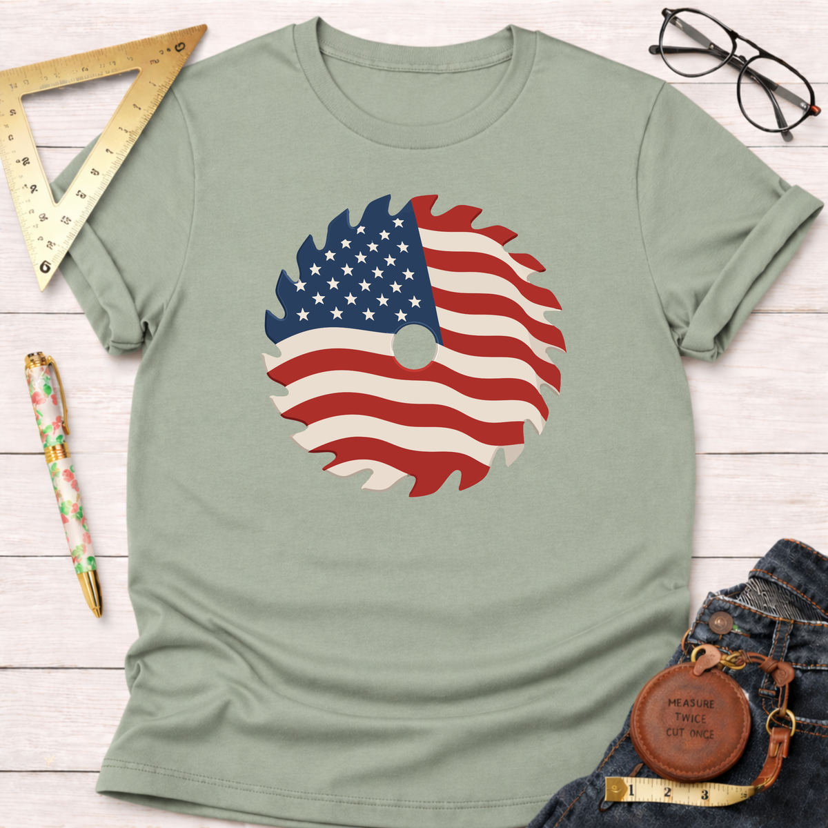Light green cotton t-shirt with a patriotic saw blade graphic, styled with jeans, ruler, and glasses.
