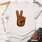 White cotton t-shirt with a wood-textured peace sign graphic, laid flat with jeans and tools.