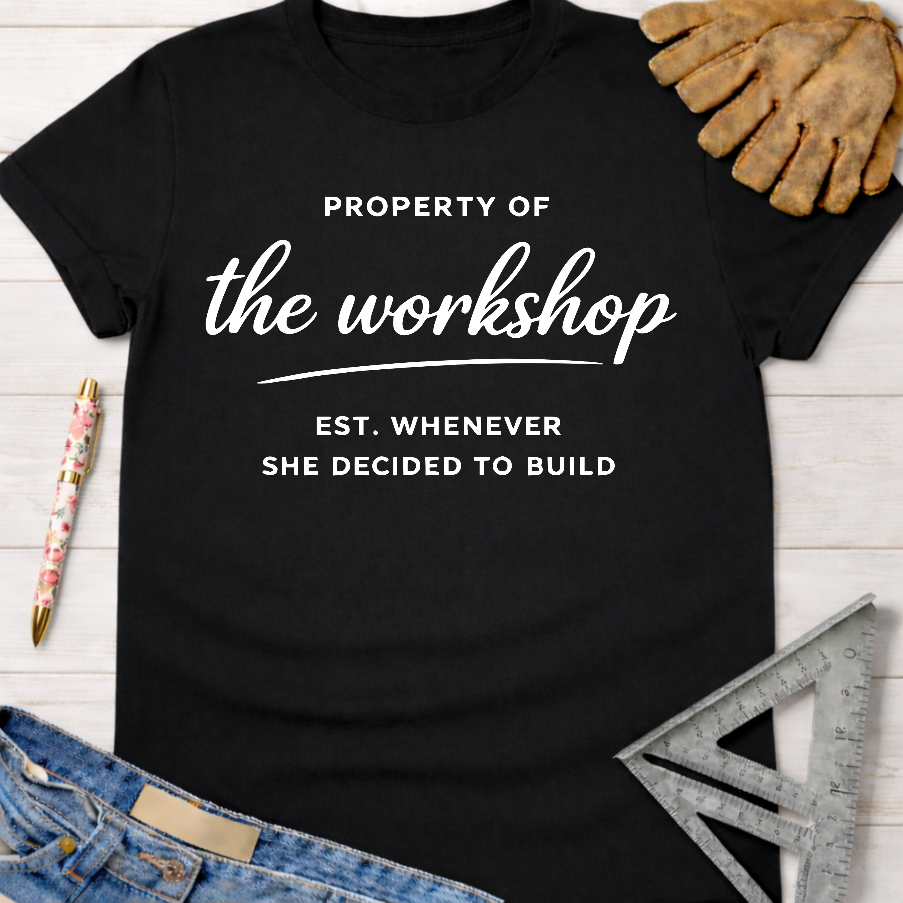 Black women's funny woodworking graphic tee with "Property of the workshop EST. WHENEVER SHE DECIDED TO BUILD" text. Sawdust & Ponytails.