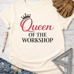 Women's funny woodworking graphic tee shirt for female woodworkers, makers, and DIY builders — Sawdust & Ponytails. Cream t-shirt with "Queen OF THE WORKSHOP" text and a crown design.