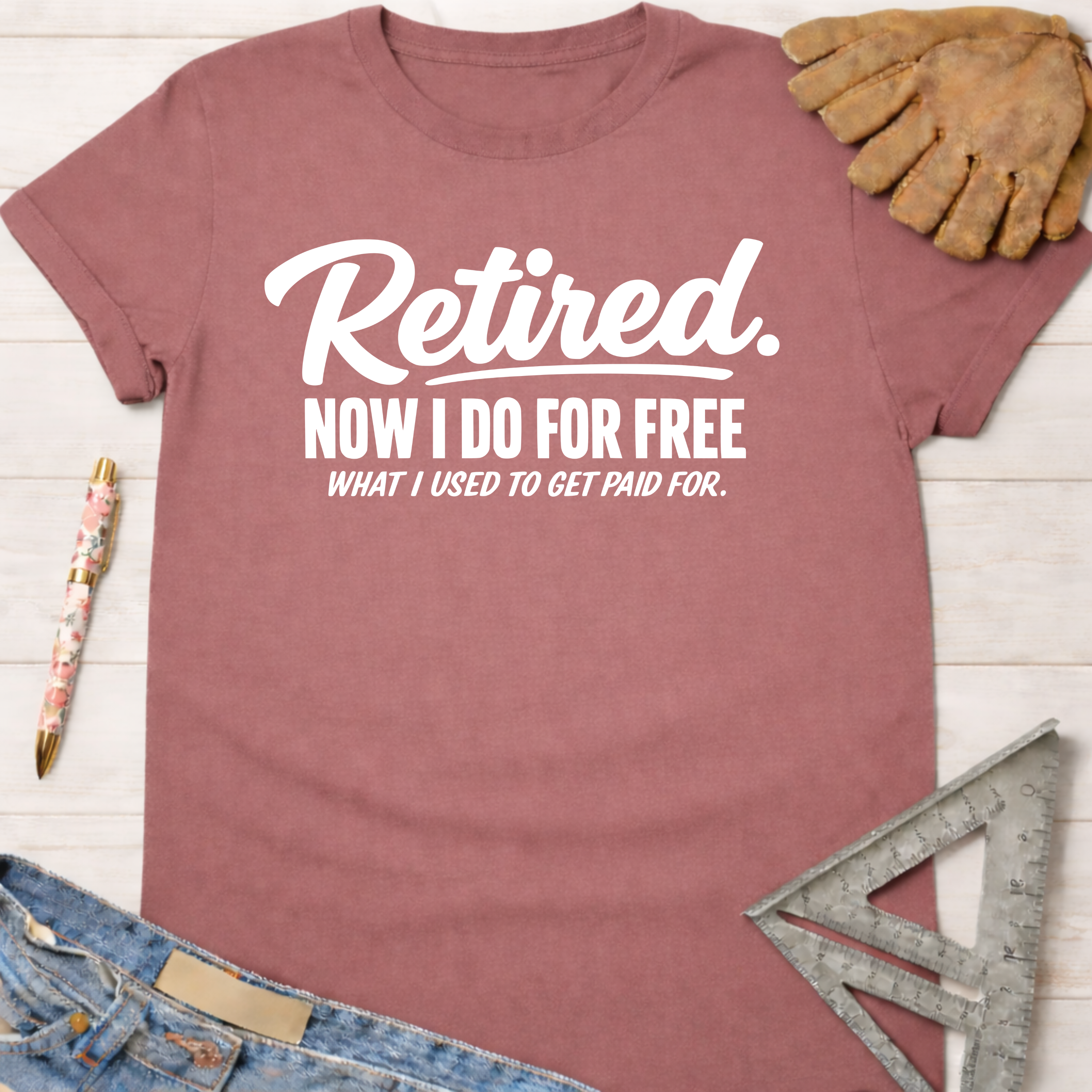 Women's funny woodworking graphic tee shirt for female woodworkers, makers, and DIY builders — Sawdust & Ponytails. Mauve cotton tee with "Retired. Now I Do For Free What I Used To Get Paid For." in white text.