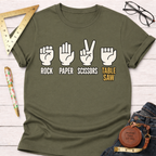 Olive green "Rock Paper Scissors Table Saw" graphic t-shirt with white and yellow text.